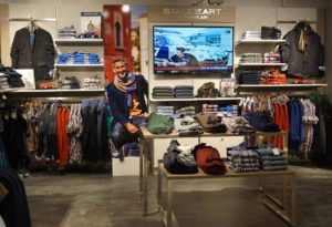 Indretning af tøjbutikker med mærke opdelte områder med egen image markedsføring på stor skærme og på mannequiner. Butiksinventar