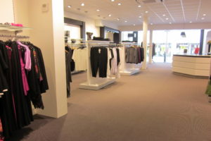 Modebutik. Stor damebutik med butiksinventar holdt i hvidt og sort som er kendetegnet for butikskonceptet