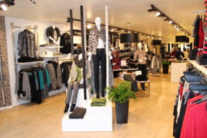 Tøjbutik med salgsområde lige indefor døren, som bruges til kampagne (annonce) varer. Butiksinventar - First