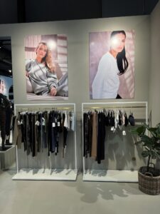 Hvit klesstativ med messing, som er anvendt i shop område